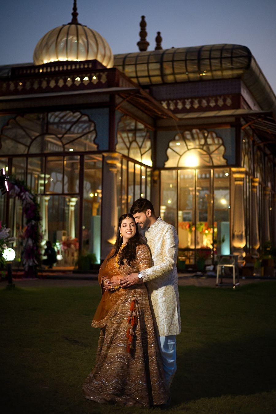 A couple at a lit heritage pavilion at night